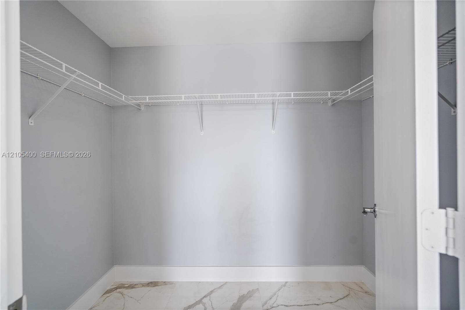 Walk-in closet with wire shelving system and light gray walls