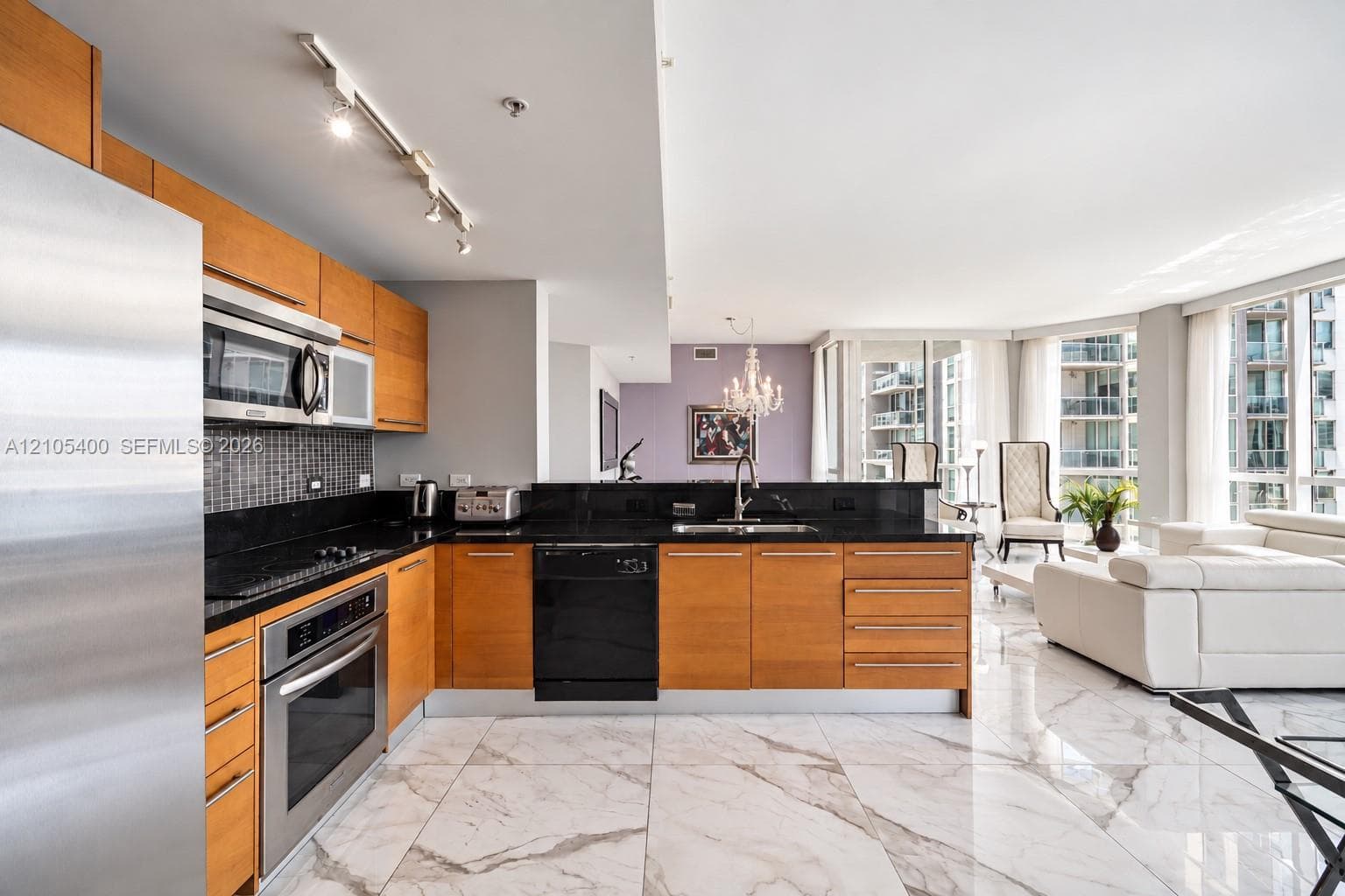 Kitchen featuring wood cabinetry, black countertops, and a tile backsplash