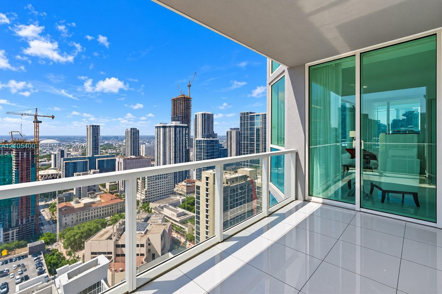 Expansive balcony with glass panel railing, offering sweeping cityscape scenery