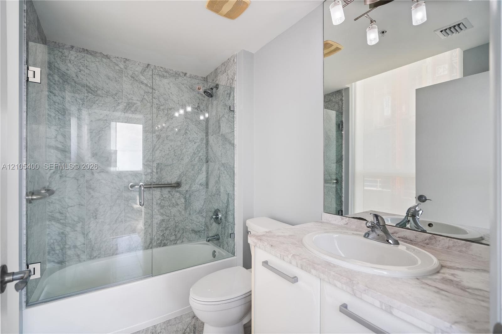 Built-in vanity with an undermount sink and stone-finish countertop
