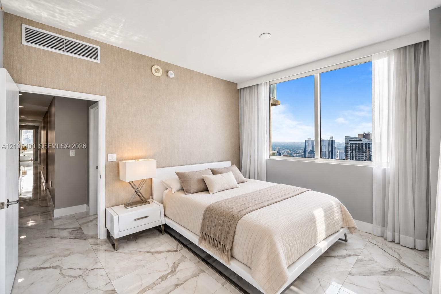 Floor-to-ceiling windows, marble-look tile flooring, textured wall covering, and recessed lighting
