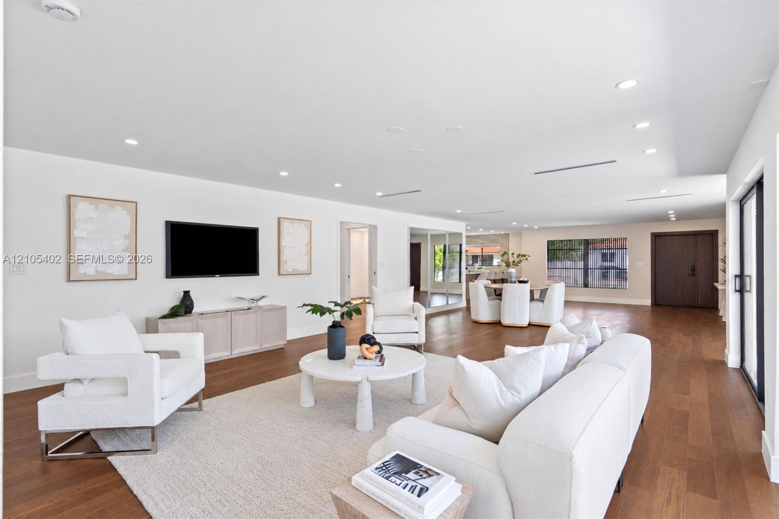 Open-concept floor plan featuring wood-finish flooring, recessed lighting, neutral interior palette, and sliding glass doors