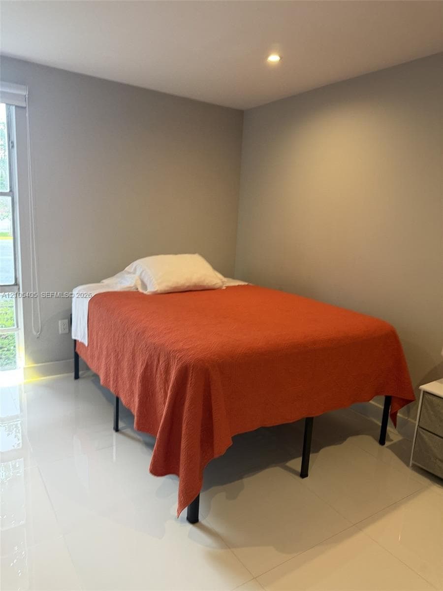 Recessed ceiling lighting, a window with blinds, and light-colored walls