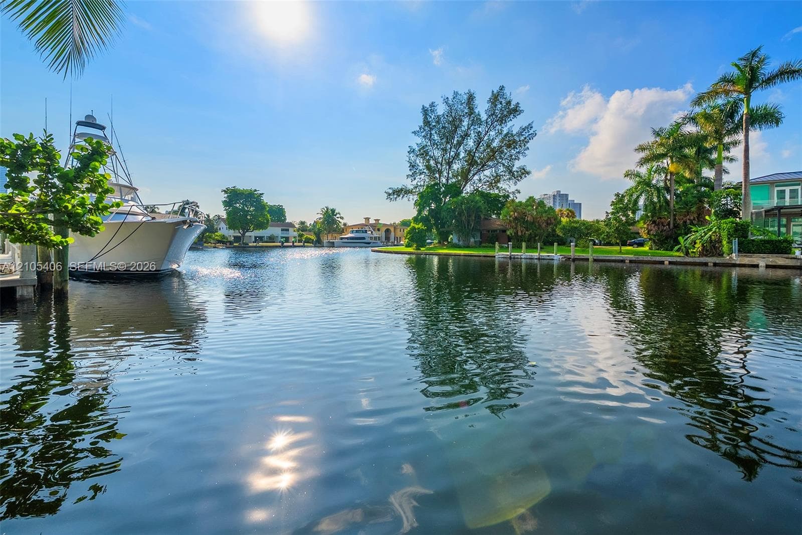 Waterfront property featuring a private boat dock, lush tropical landscaping, and canal access