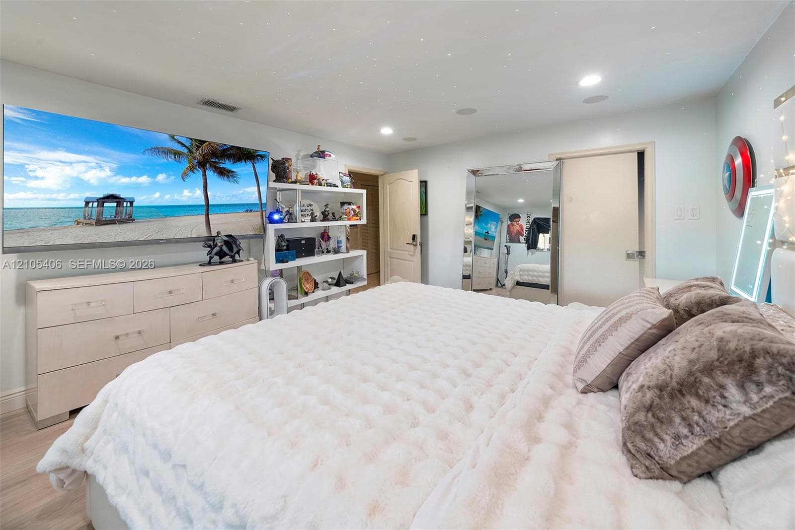 Recessed lighting, wood-finish flooring, built-in shelving, mirrored closet doors, and a built-in wall screen