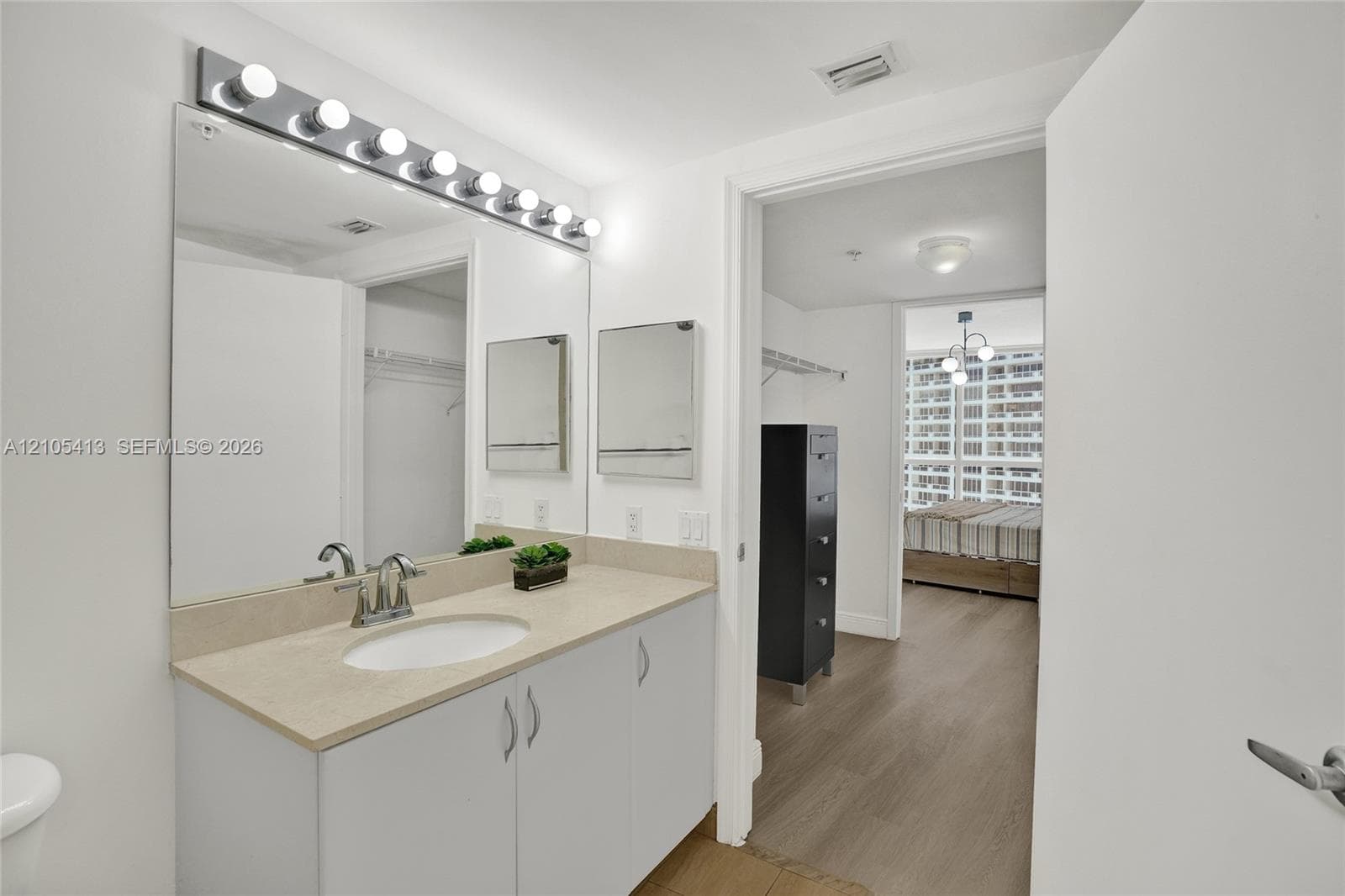 Vanity with a single basin, light-toned countertop, and integrated storage cabinetry