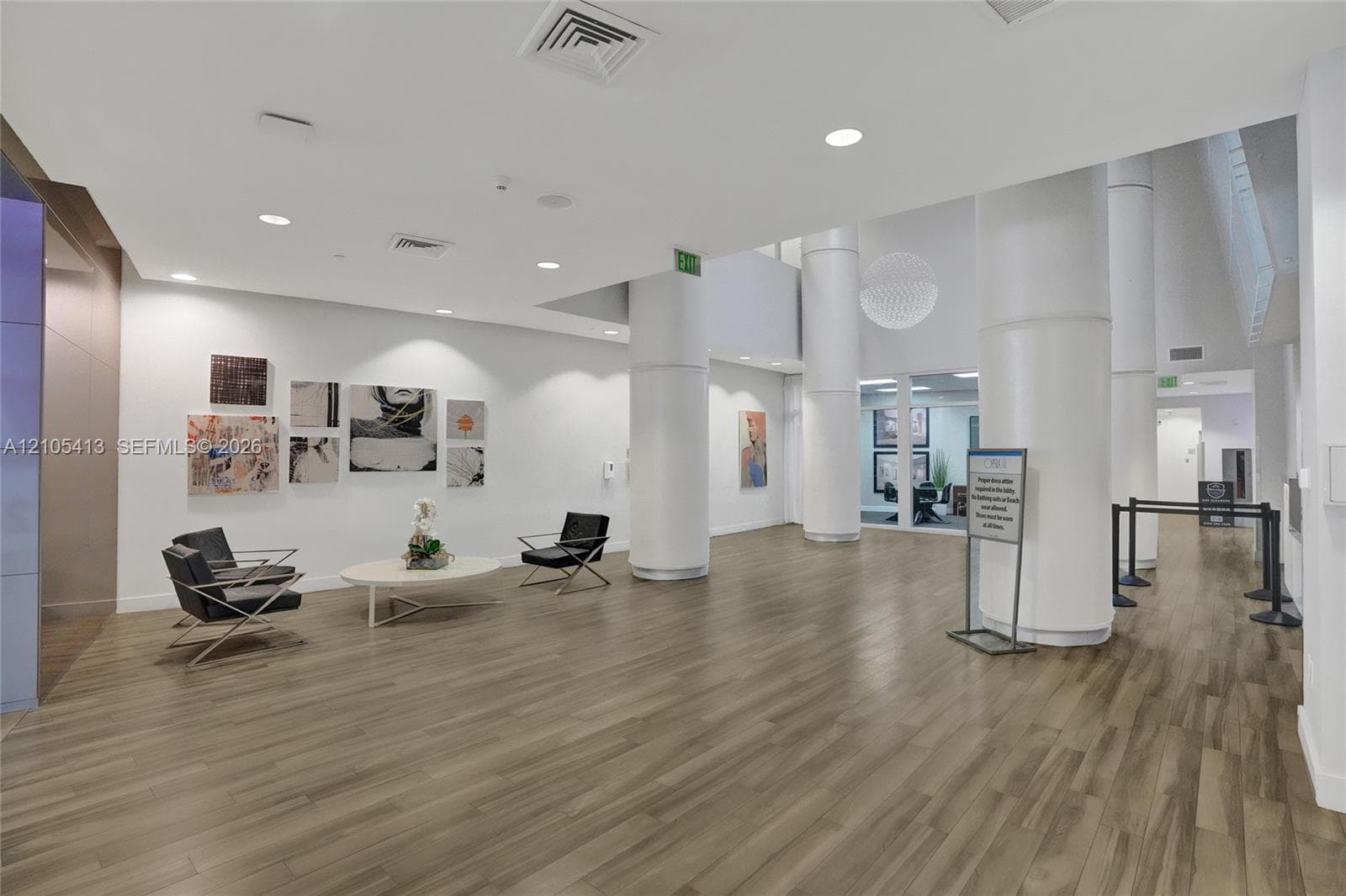 Spacious common area featuring wood-finish flooring, recessed lighting, and white support columns