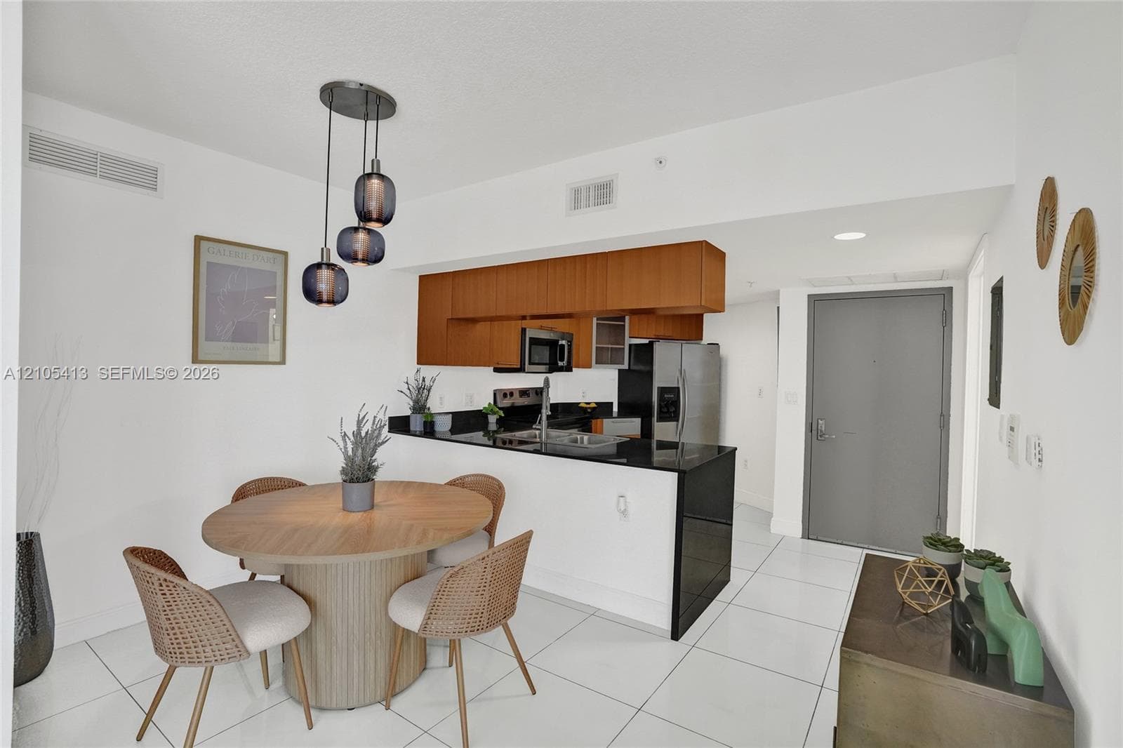 Kitchen with black countertops, stainless steel appliances, and wood-finish cabinetry