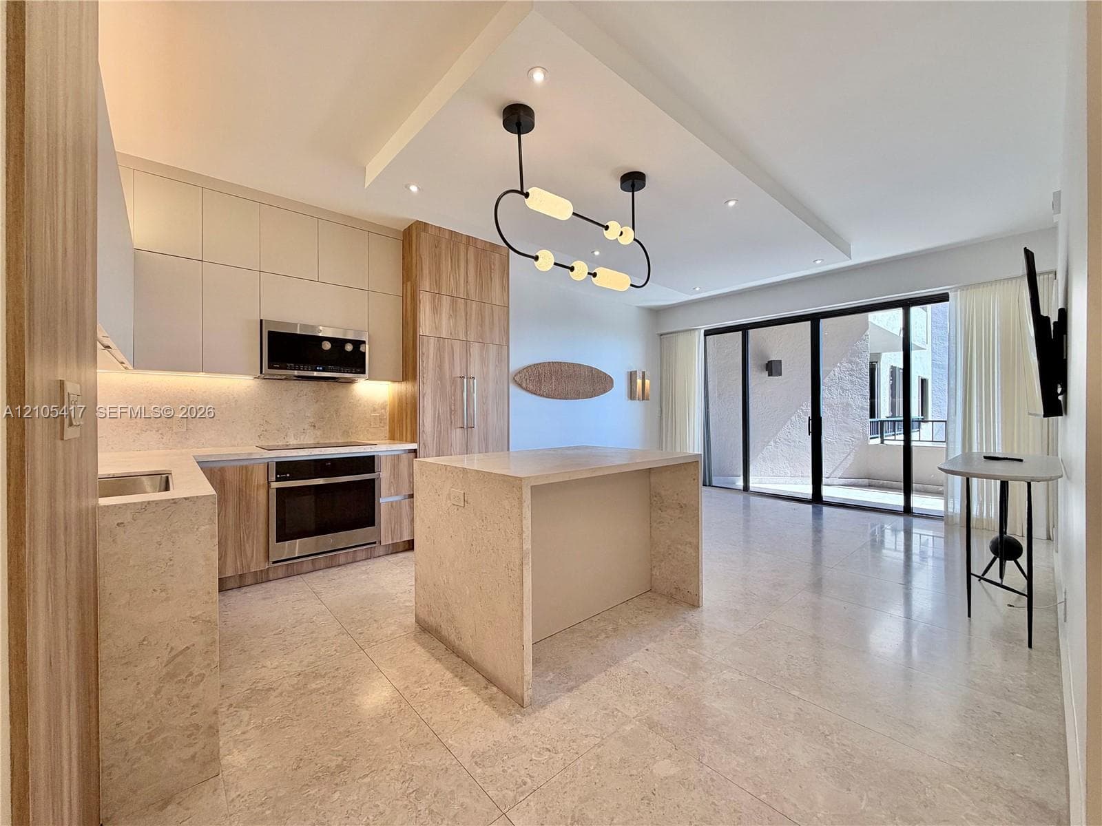 Contemporary kitchen with integrated appliances, light-toned cabinetry, and a stone-clad island