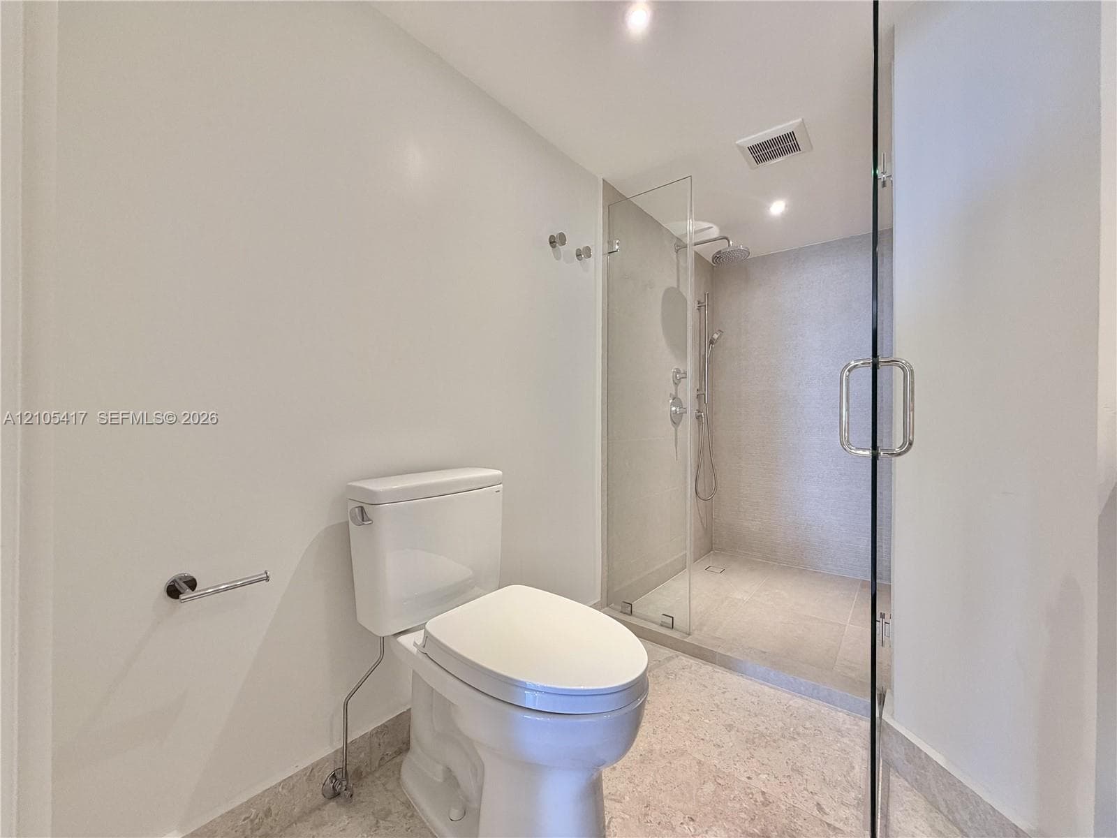 Full glass-enclosed shower with a rainfall showerhead, handheld shower fixture, and polished chrome hardware