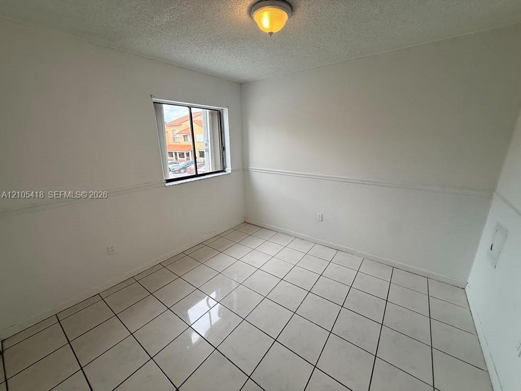 Recessed window, white tile flooring, white walls with chair rail molding, and a flush mount ceiling light
