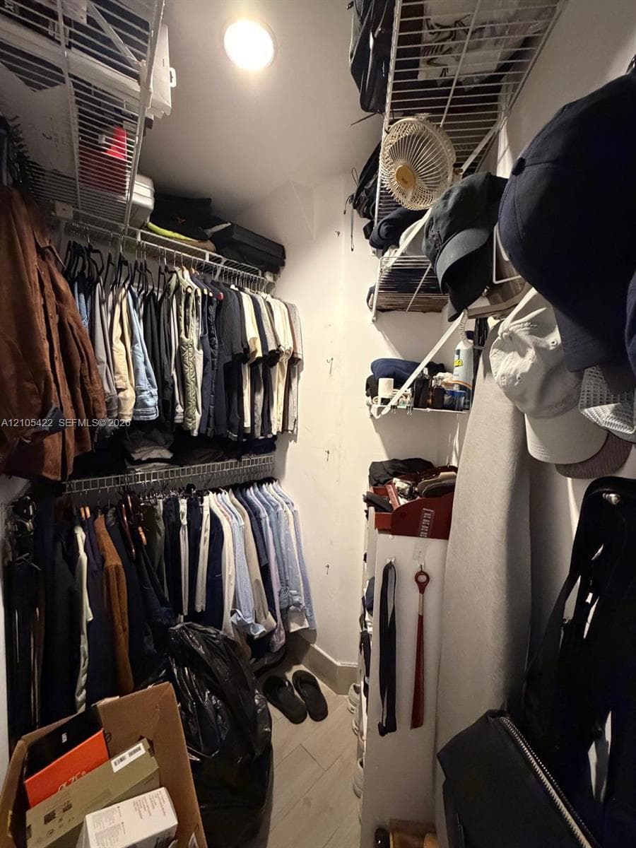 Walk-in closet featuring multi-level wire shelving and neutral tile flooring