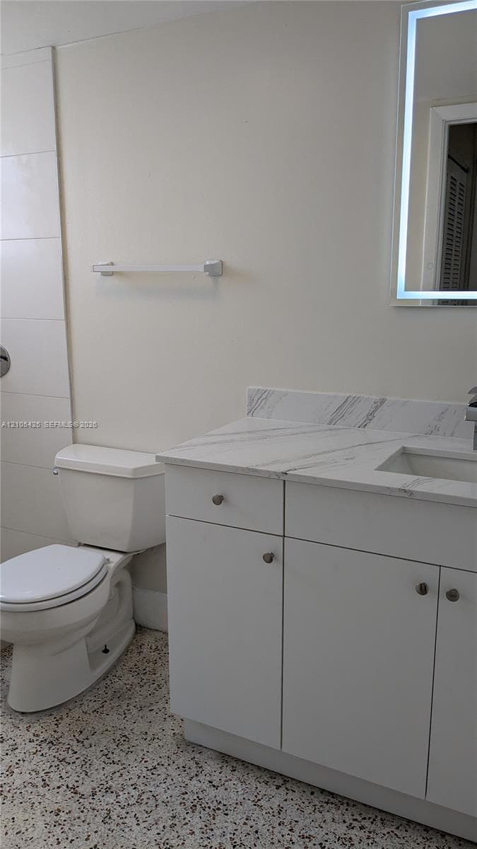 White vanity with a light-toned countertop, integrated sink, and chrome hardware