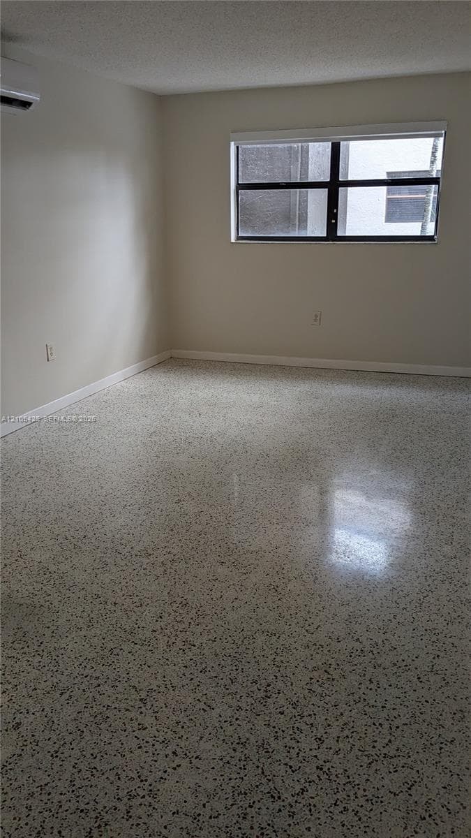 Polished terrazzo flooring, neutral wall tones, and a window with a roller shade