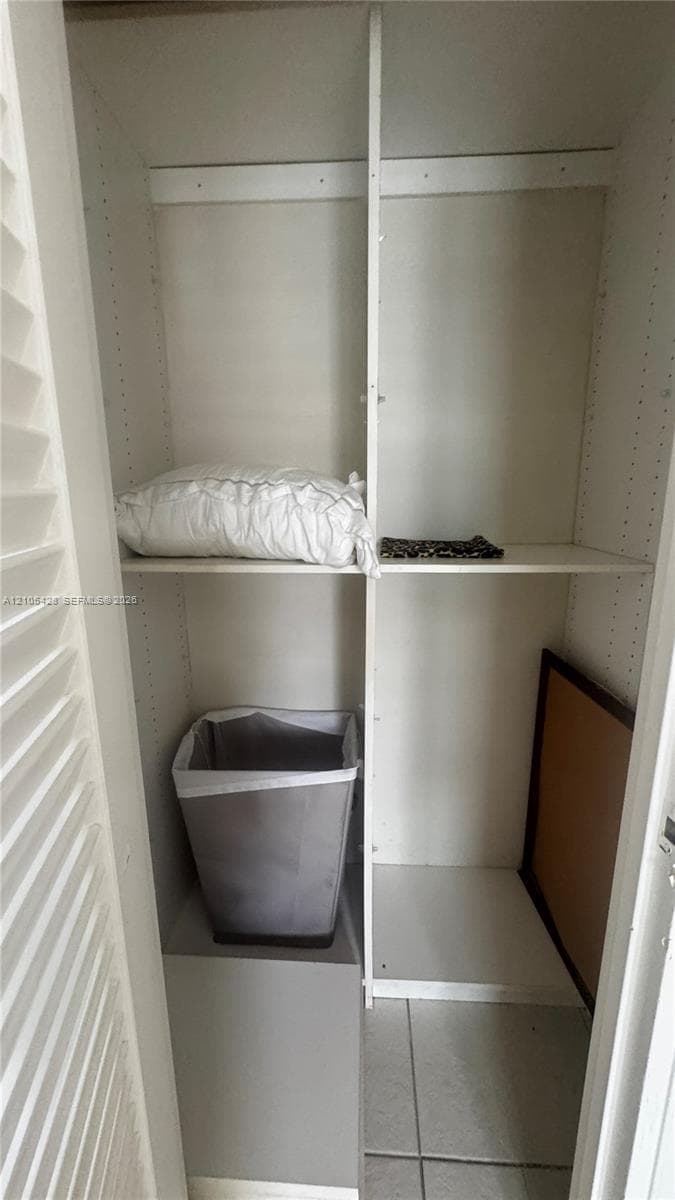 Walk-in closet with built-in shelving, integrated drawers, and a full-length mirror