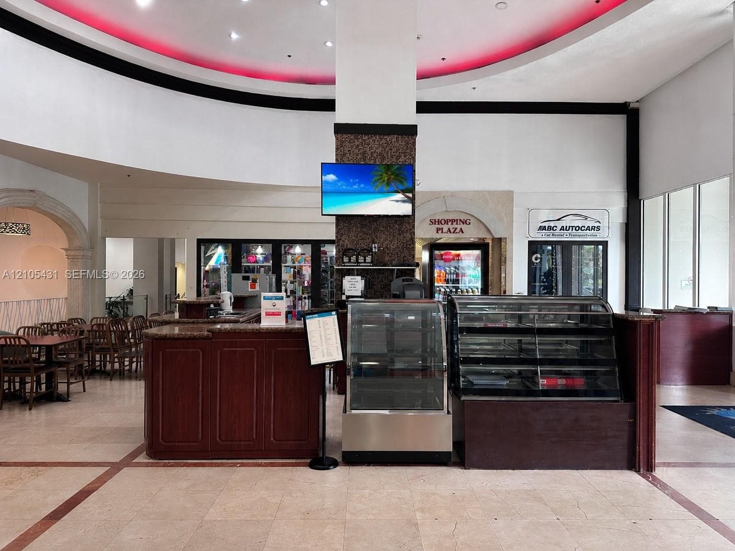 Interior commercial space featuring tile flooring, a built-in wood-finish counter, and integrated display cases