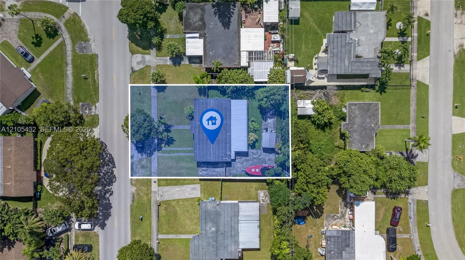 Aerial perspective of a rectangular lot featuring a residence with a flat roof, an attached side structure, and mature vegetation