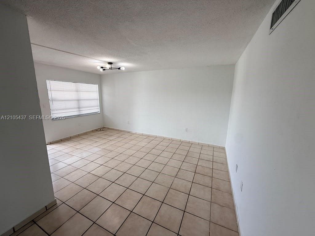Recessed lighting, tile flooring, and neutral wall tones