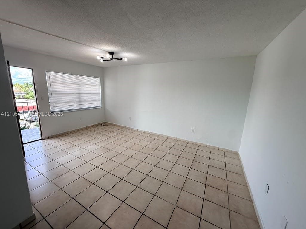 Tiled flooring throughout, neutral paint finishes, flush-mount lighting, and window with horizontal blinds