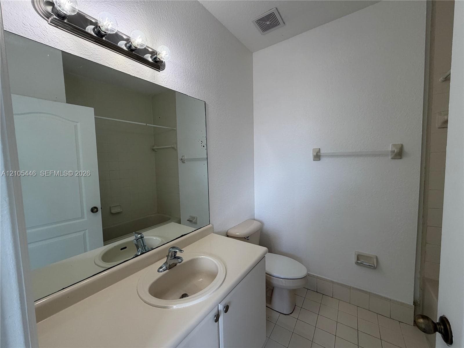 Wood-finish flooring, white walls, recessed ceiling lighting, and a closet with bifold doors