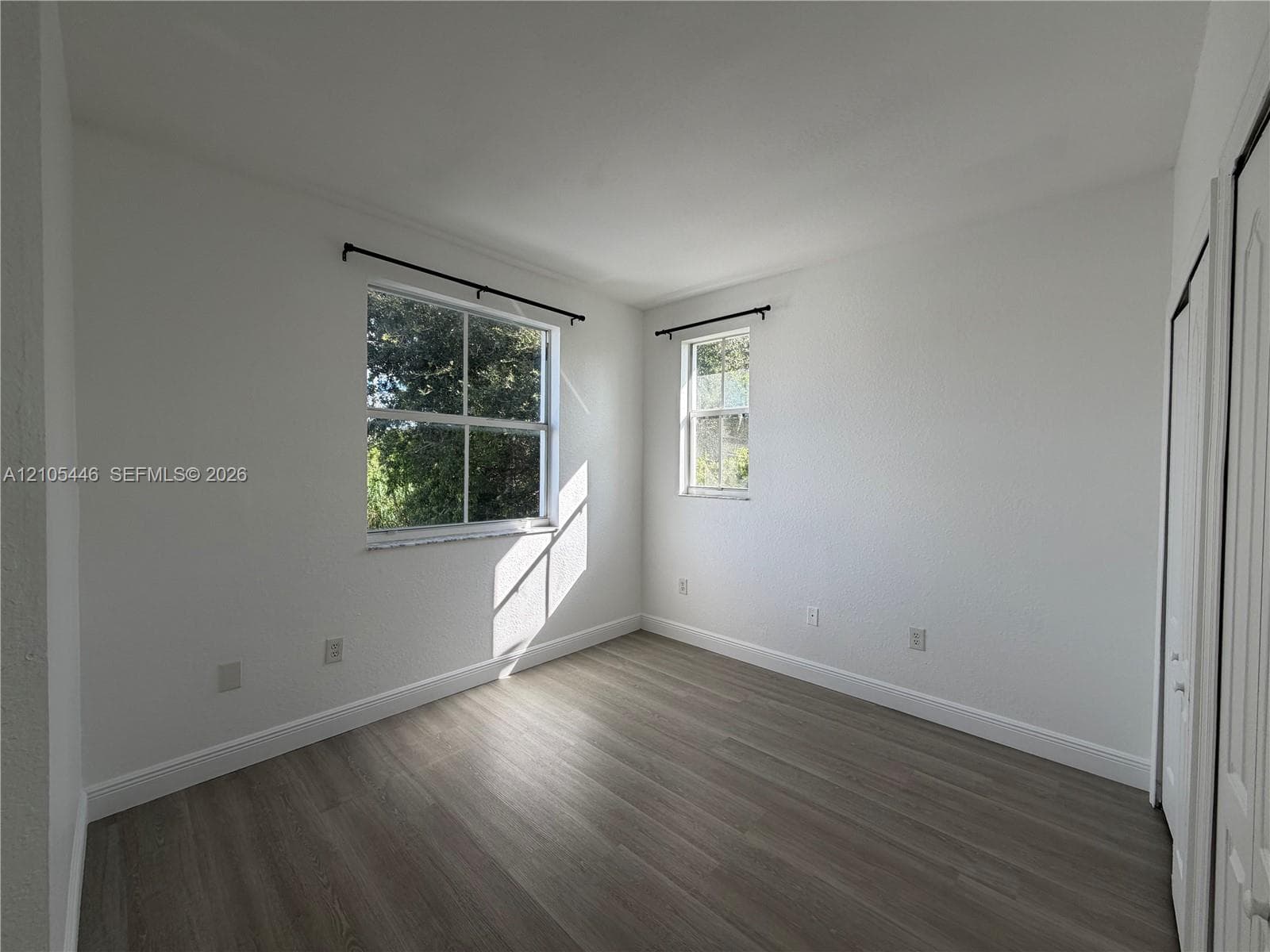 Neutral wall finishes, wood-finish flooring, and two windows