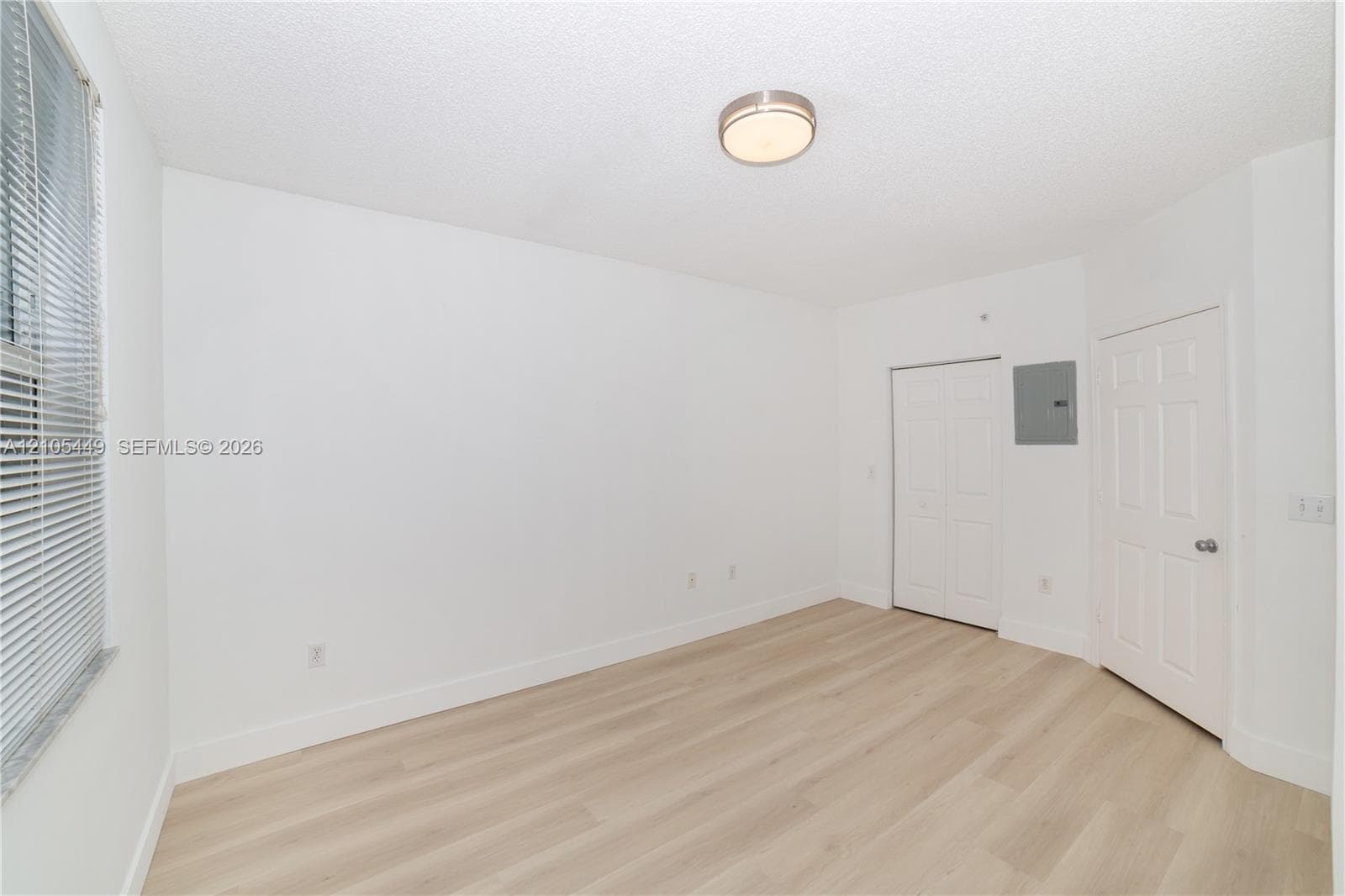 Light wood-finish flooring with white baseboards