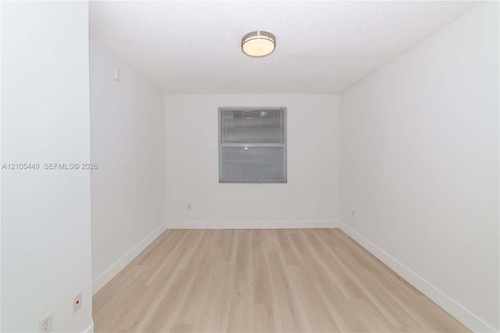 Light wood-finish flooring with white baseboards
