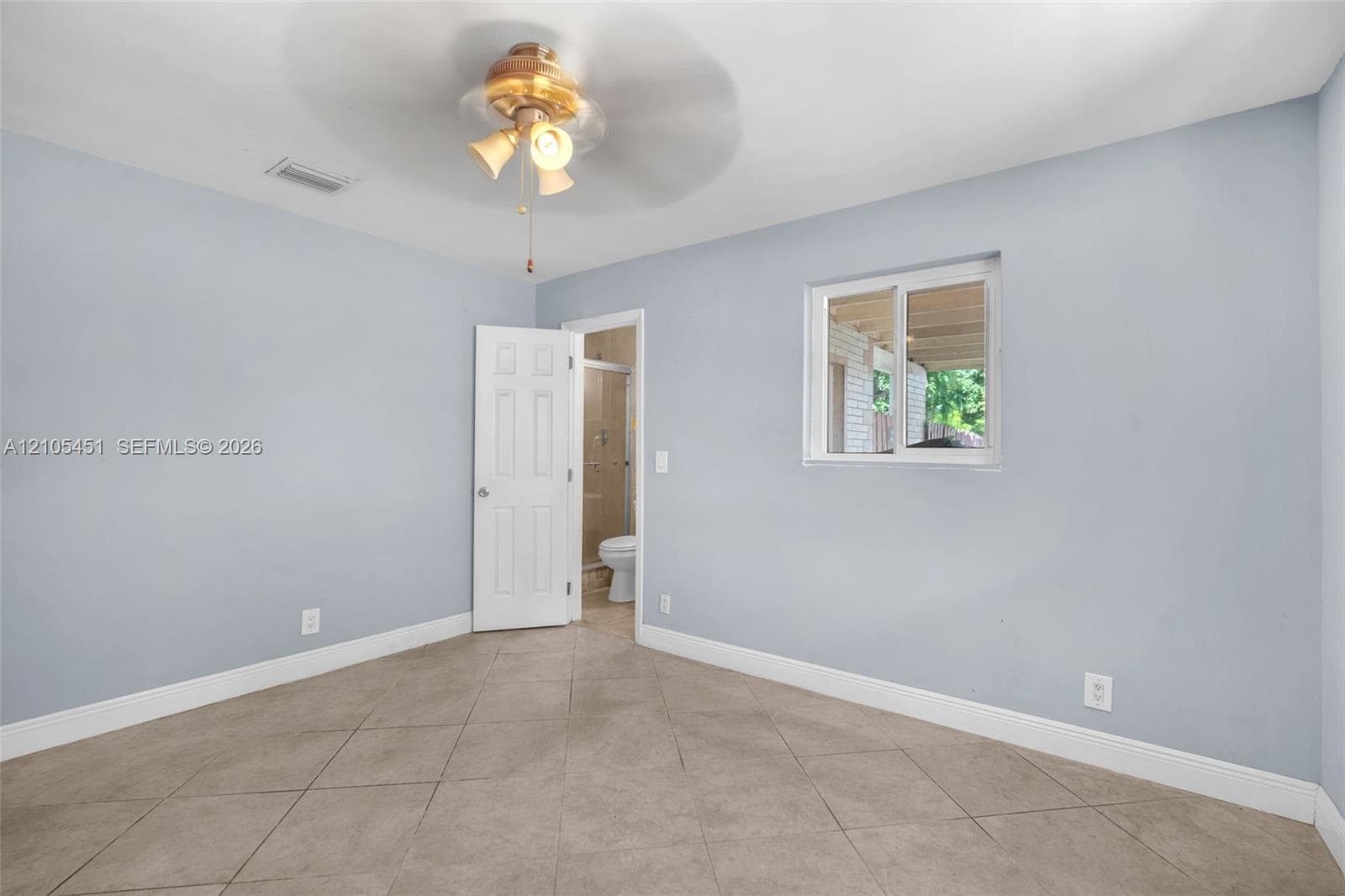 Neutral-toned interior space featuring large-format diagonal tile flooring, a multi-light ceiling fan, and a horizontal sliding window