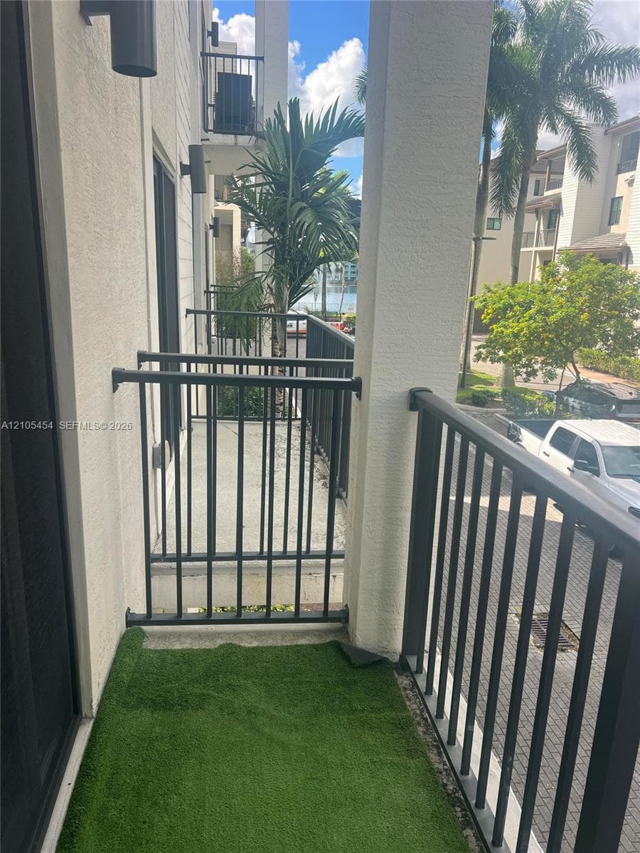 Balcony with metal railings, outdoor wall sconces, and a partial water scene