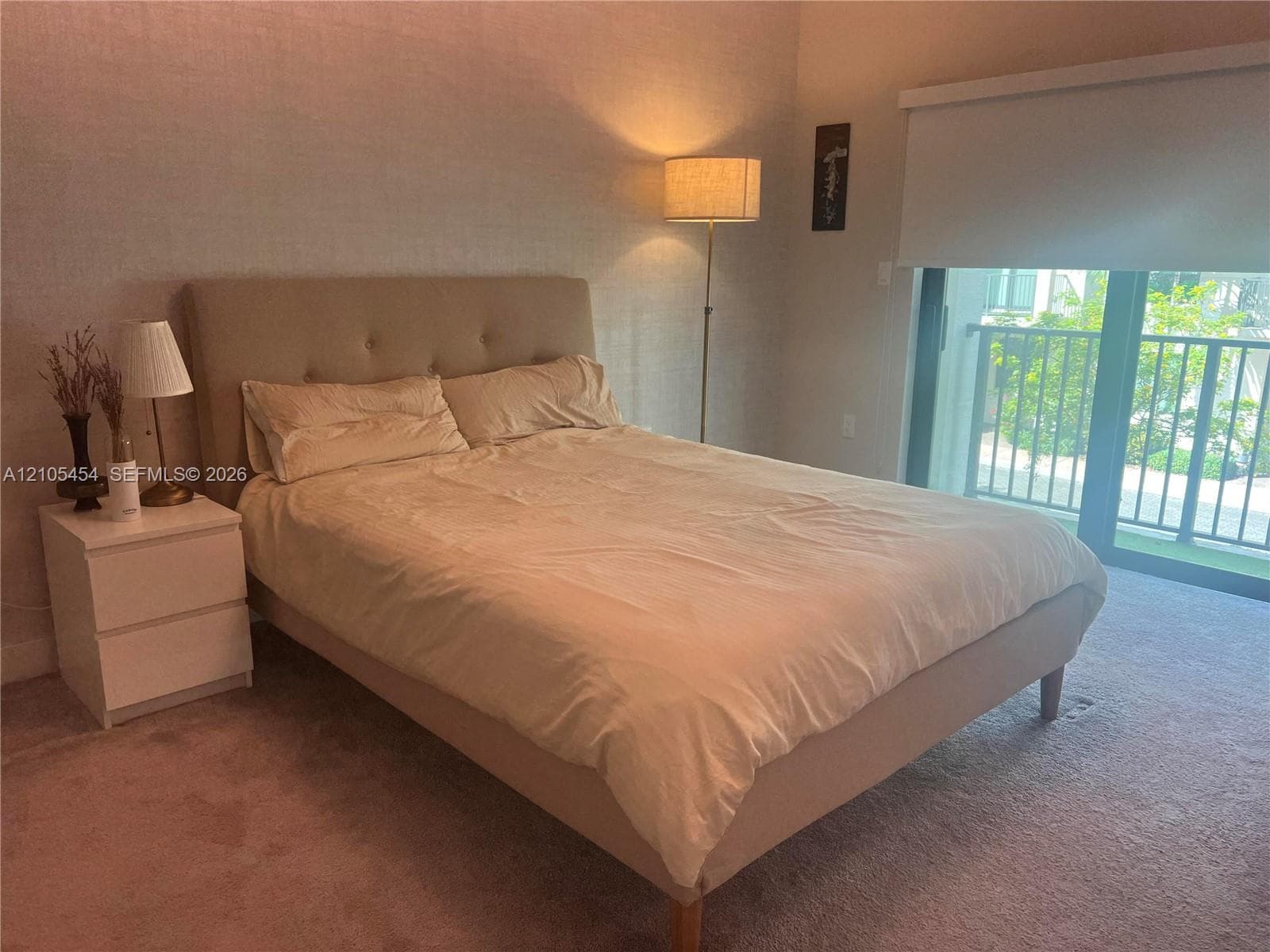 Carpeted flooring, glass sliding door, and a private balcony with railing