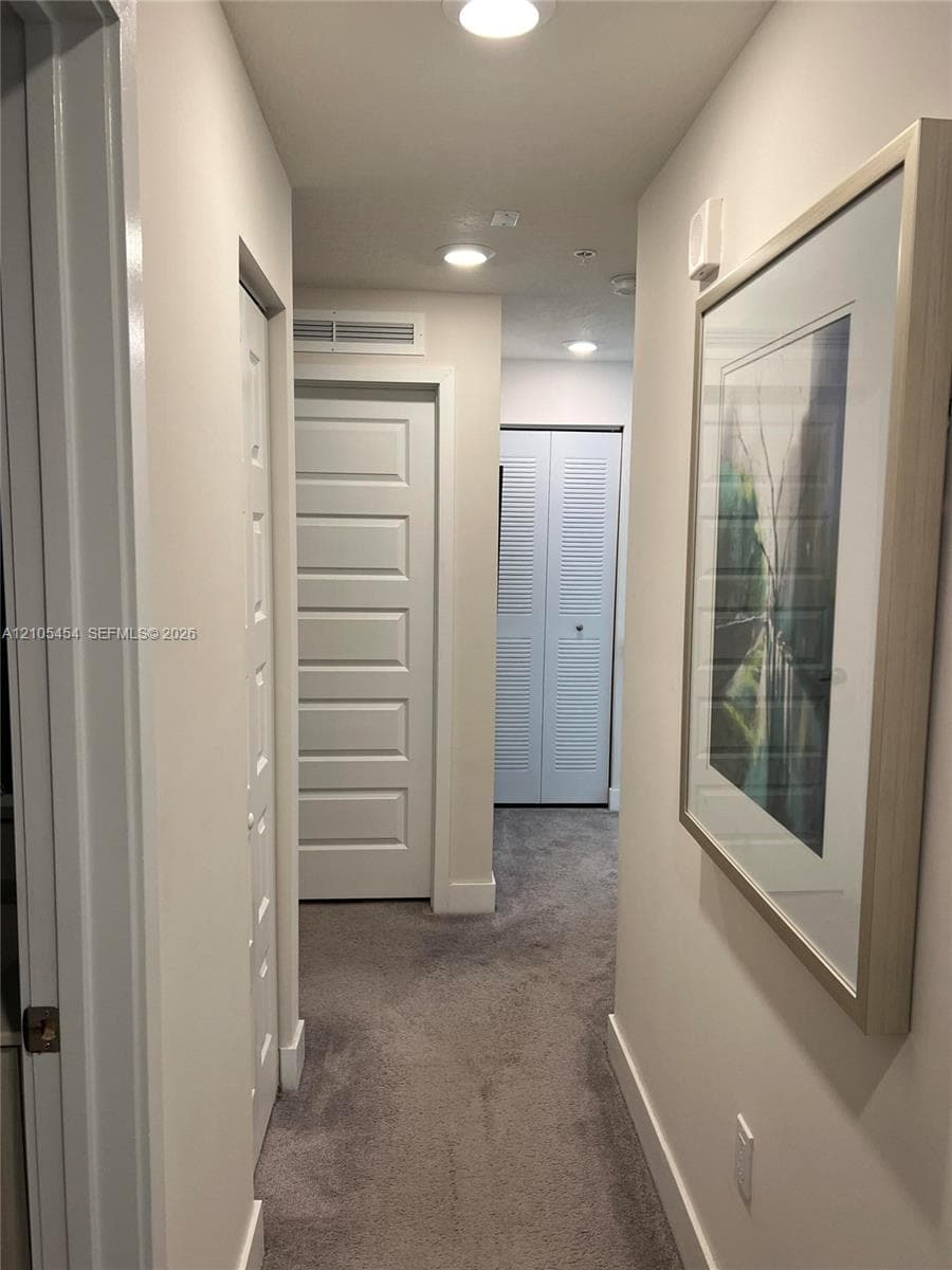 Recessed lighting, plush carpeting, white interior doors, and crisp white trim
