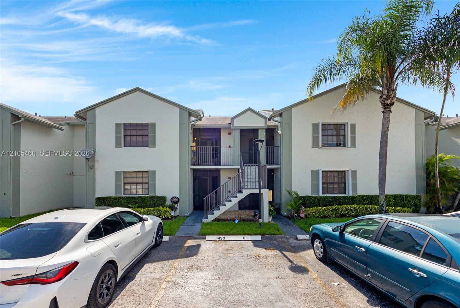 Two-story residence featuring exterior shutters, a private entrance, and an upper-level balcony