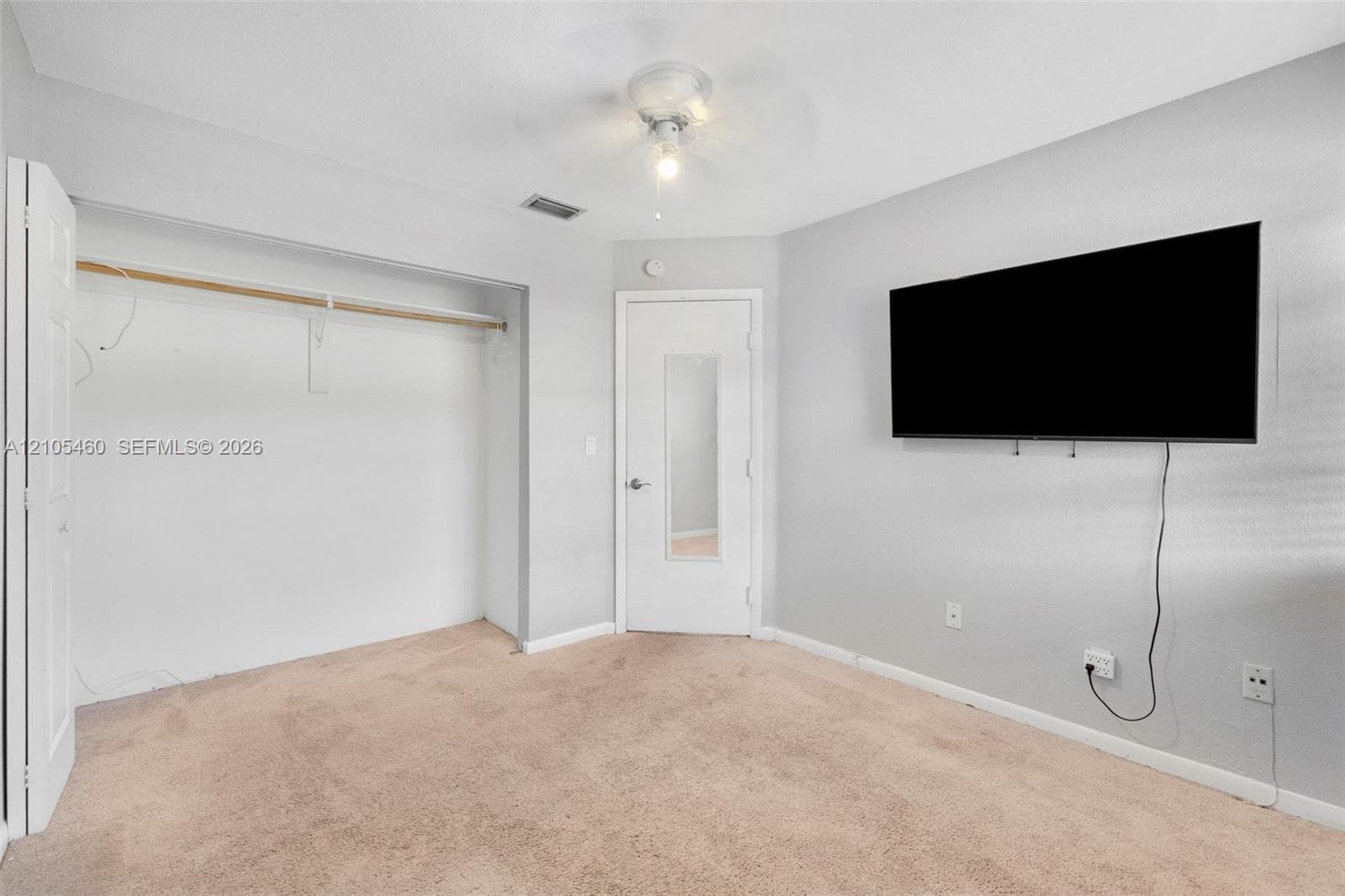 Neutral wall colors, ceiling fan, and carpeted flooring