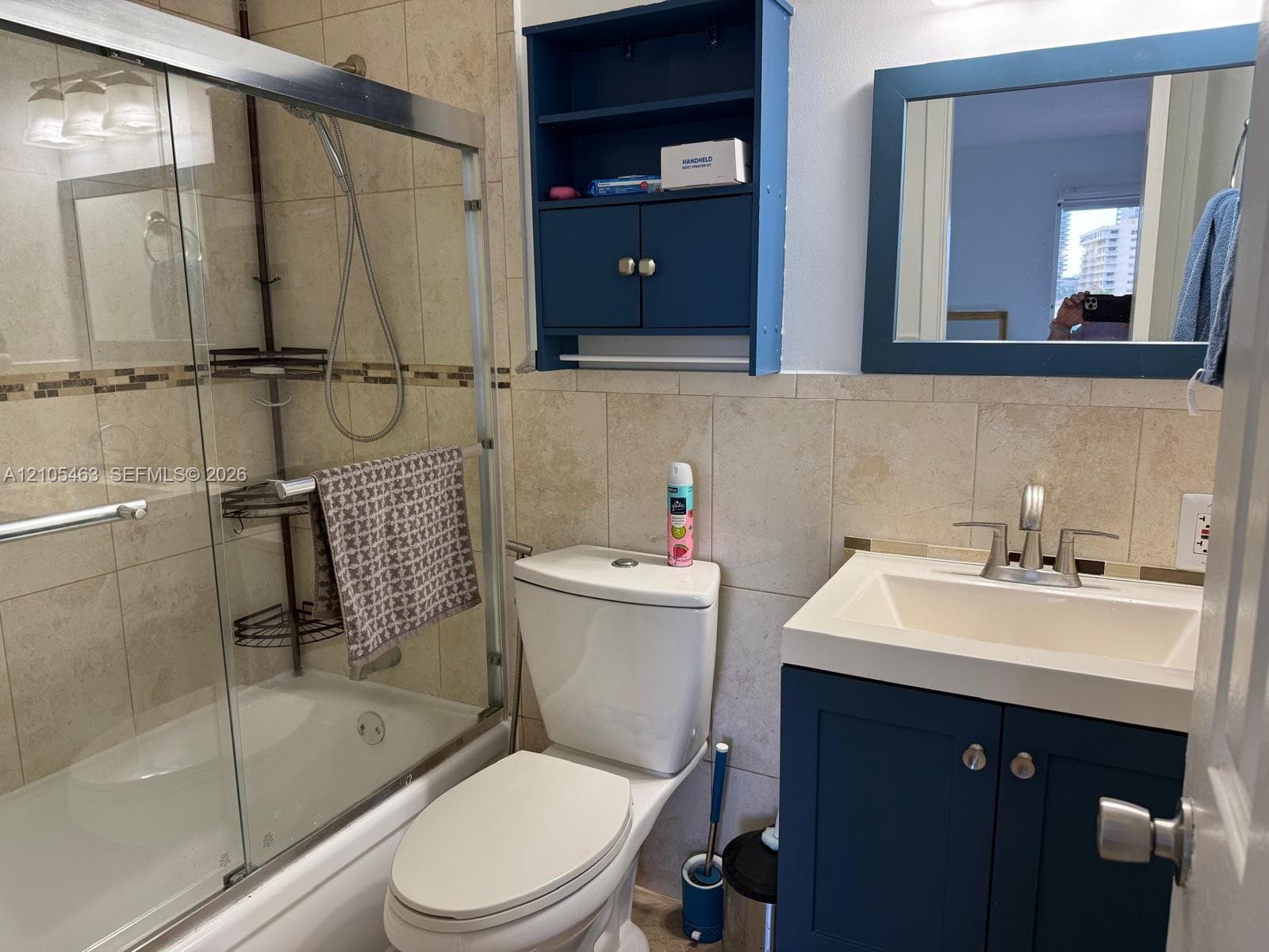 Bathroom featuring a white vanity with integrated sink, chrome faucet, and a blue cabinet base