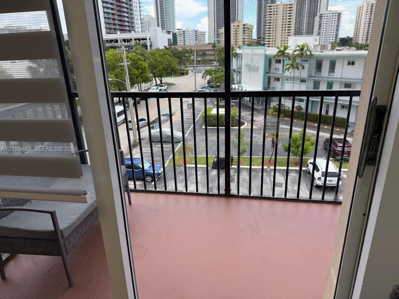 Balcony with black metal railing and a terracotta-toned floor