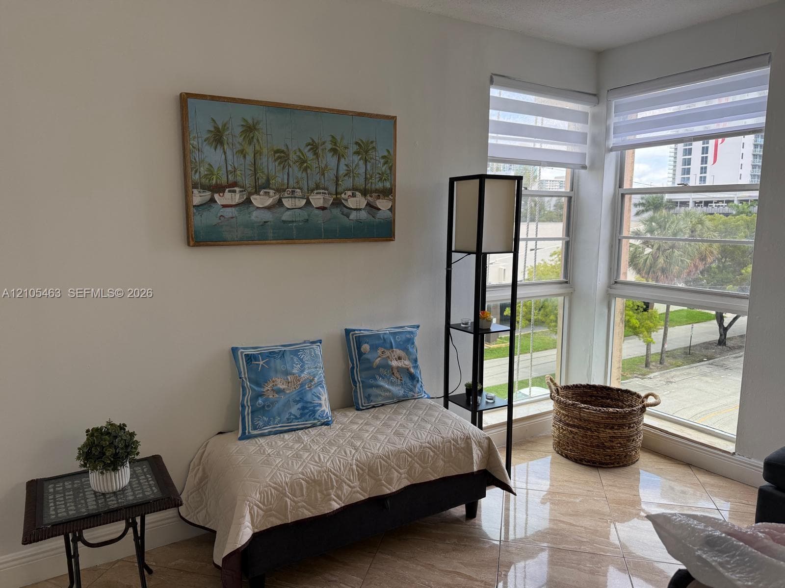 Corner windows with horizontal blinds, providing natural light, and tile flooring