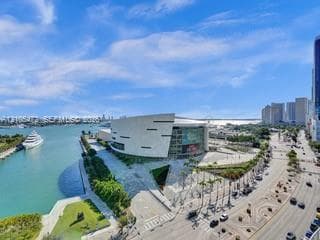 Expansive cityscape with prominent waterway, a large white vessel, and a modern architectural structure
