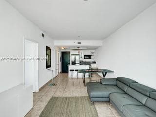 Open-concept living area featuring tile flooring, white walls, and recessed lighting