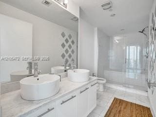 Dual vessel sinks with chrome fixtures set into a light-toned countertop