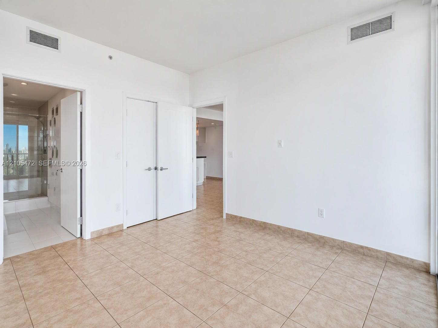 Neutral-toned tile flooring, white interior doors, and recessed ceiling lighting