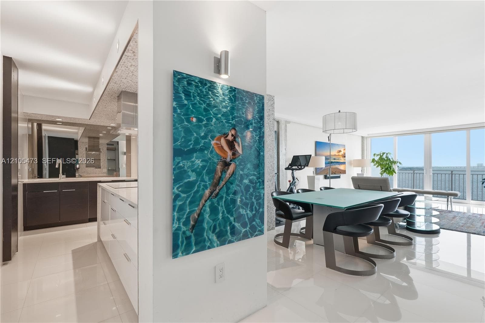 Gourmet kitchen with dark wood-finish cabinetry, a large central island with integrated storage, and a light-toned backsplash