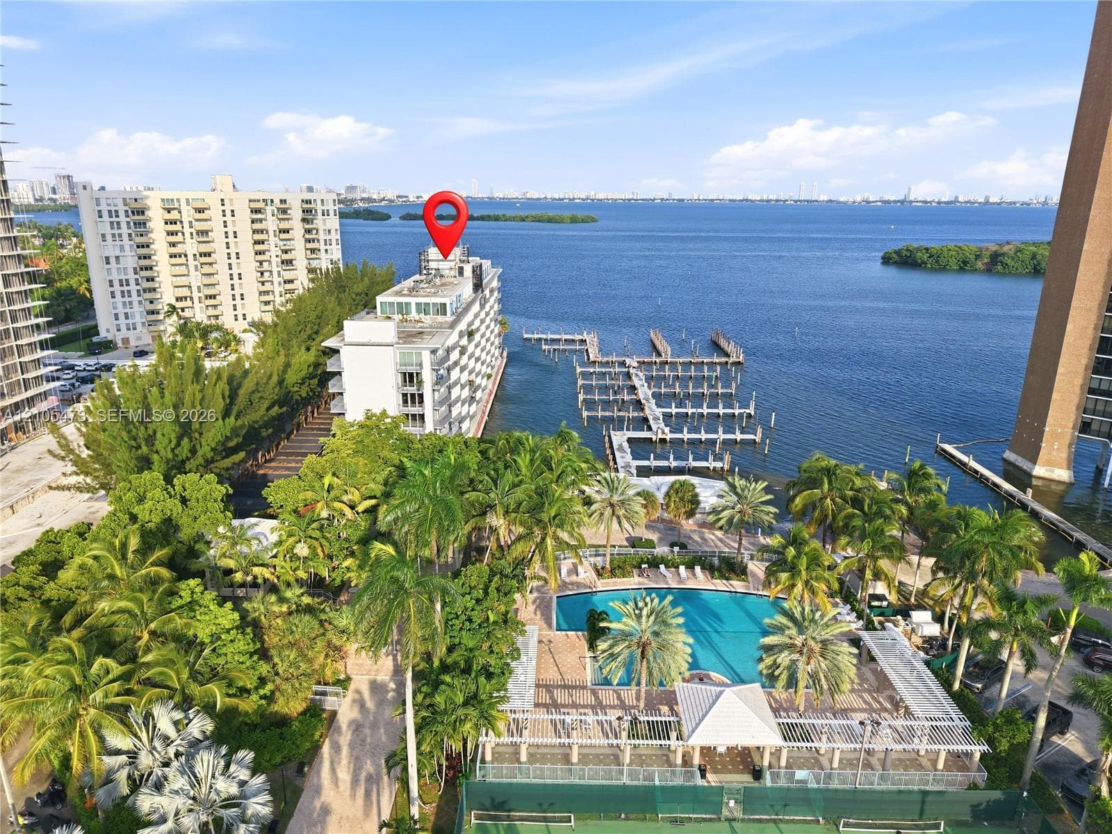 Waterfront property featuring extensive boat slips, a swimming pool, and a tennis court
