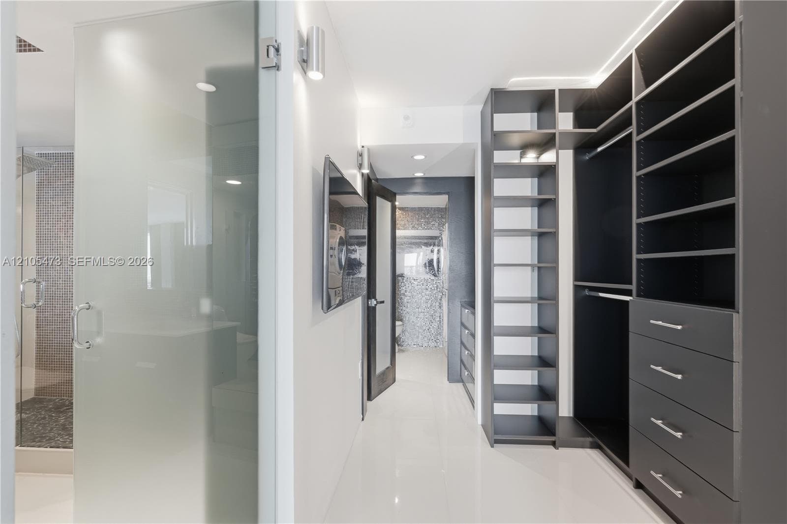 Custom closet organization system featuring built-in shelving and drawers