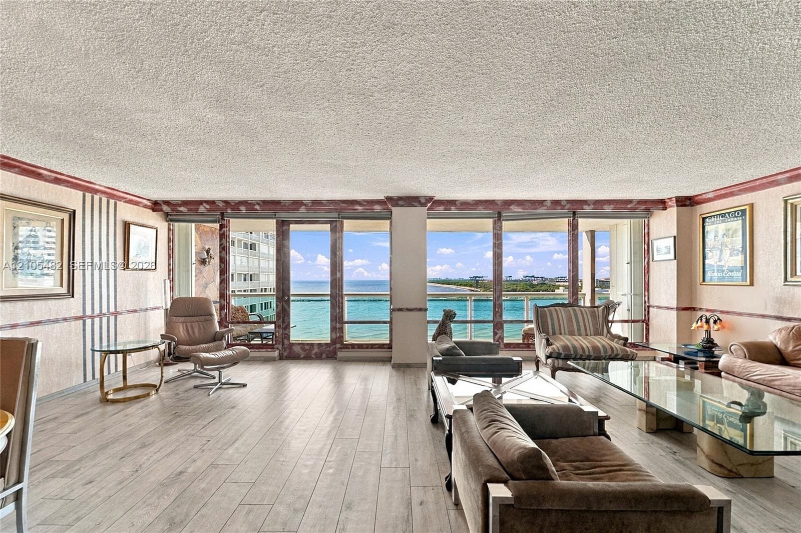 Expansive floor-to-ceiling windows, wood-finish flooring, and built-in wall trim details featuring decorative stone-finish accents
