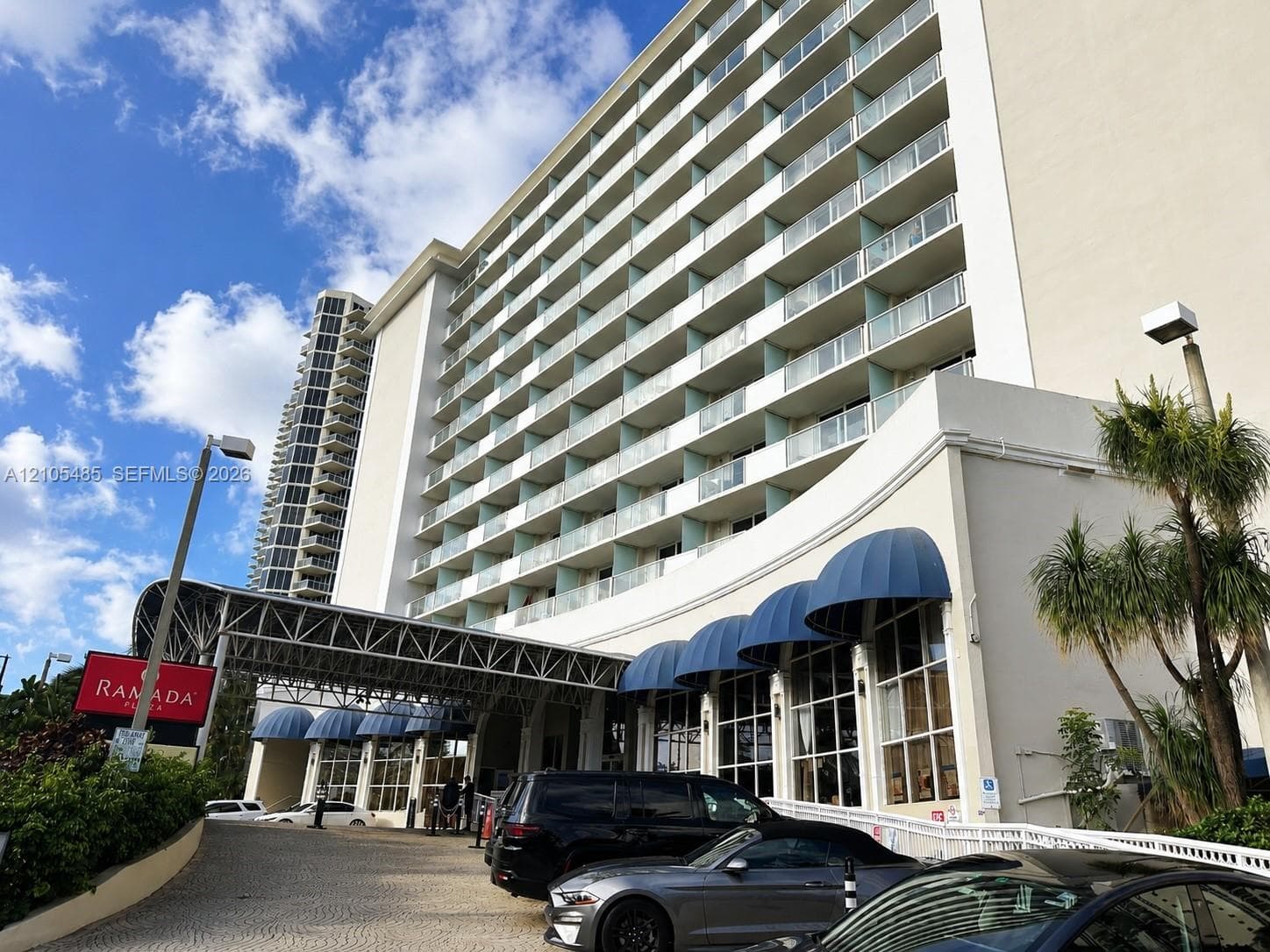 Multi-story building featuring numerous balconies with glass railings