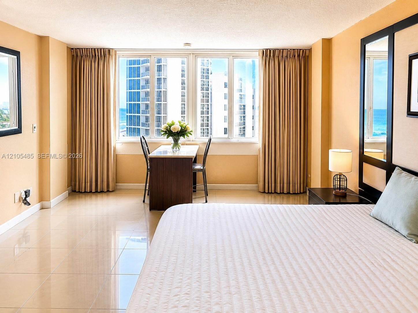 Expansive window wall, tiled flooring, built-in desk, and full-length wall mirror