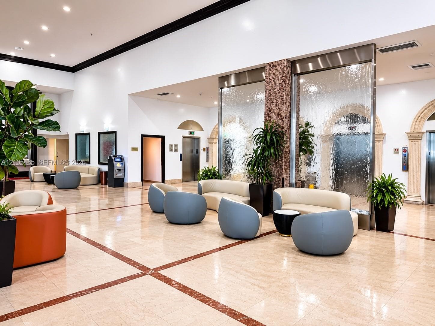 Spacious open common area featuring polished tile flooring with inlaid accents, high ceilings, and recessed lighting