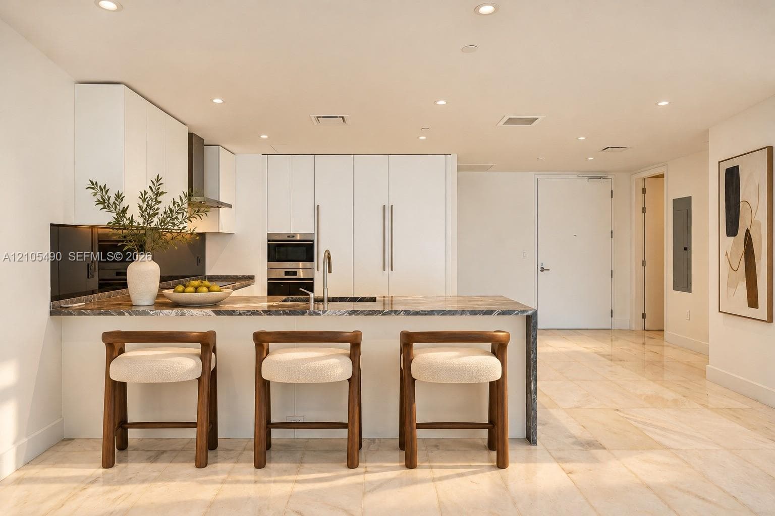Modern kitchen featuring flat-panel cabinetry, stone countertops, integrated stainless steel appliances, recessed lighting, and large-format tile flooring