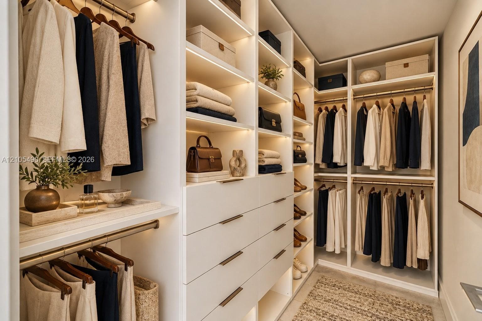 Walk-in closet featuring custom white cabinetry, integrated LED shelf lighting, stacked dresser drawers with metallic pulls, and multiple tiered hanging rods