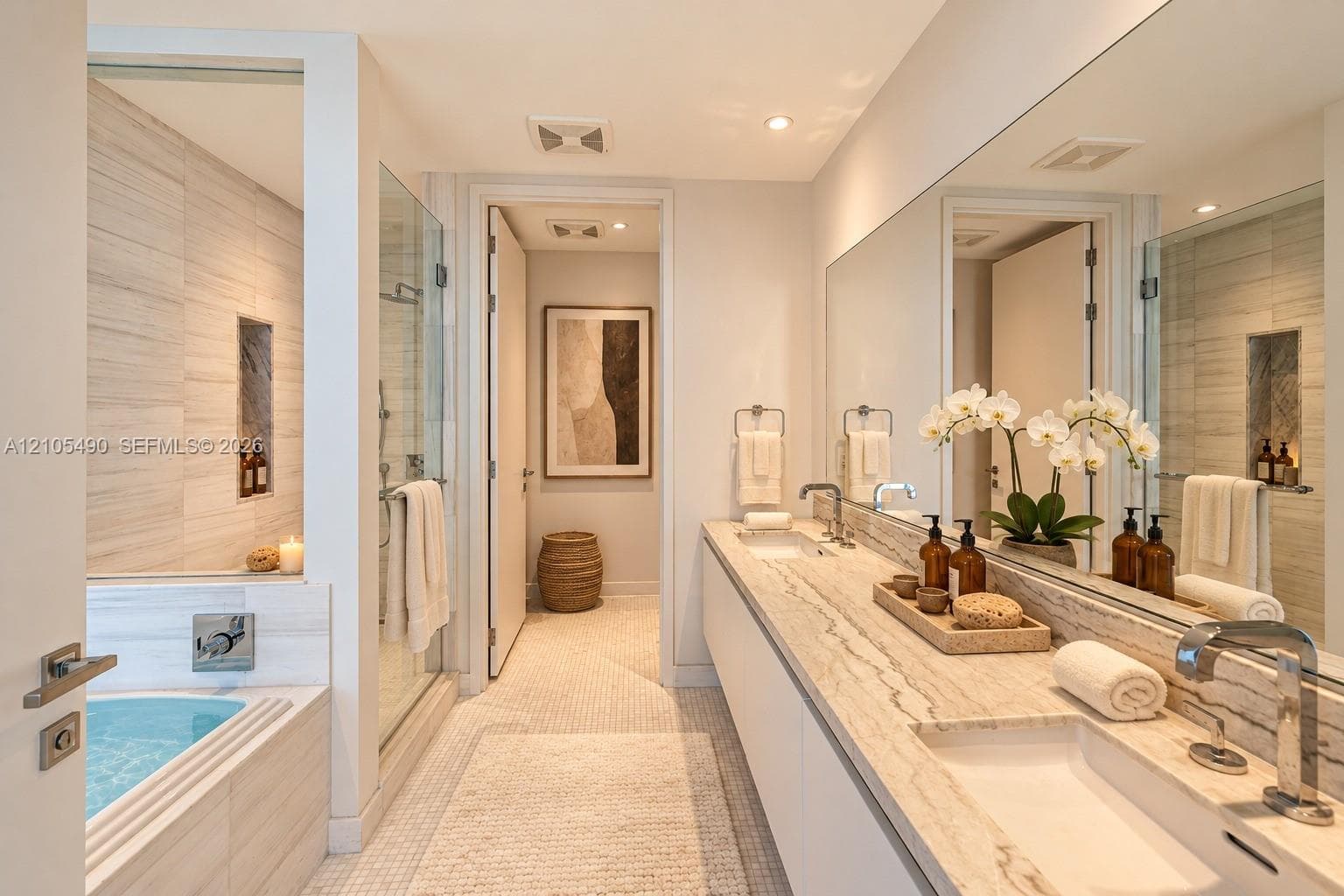 Dual-sink vanity with stone countertop, oversized wall-to-wall mirror, glass-enclosed shower, soaking tub with tile surround, and recessed wall niche